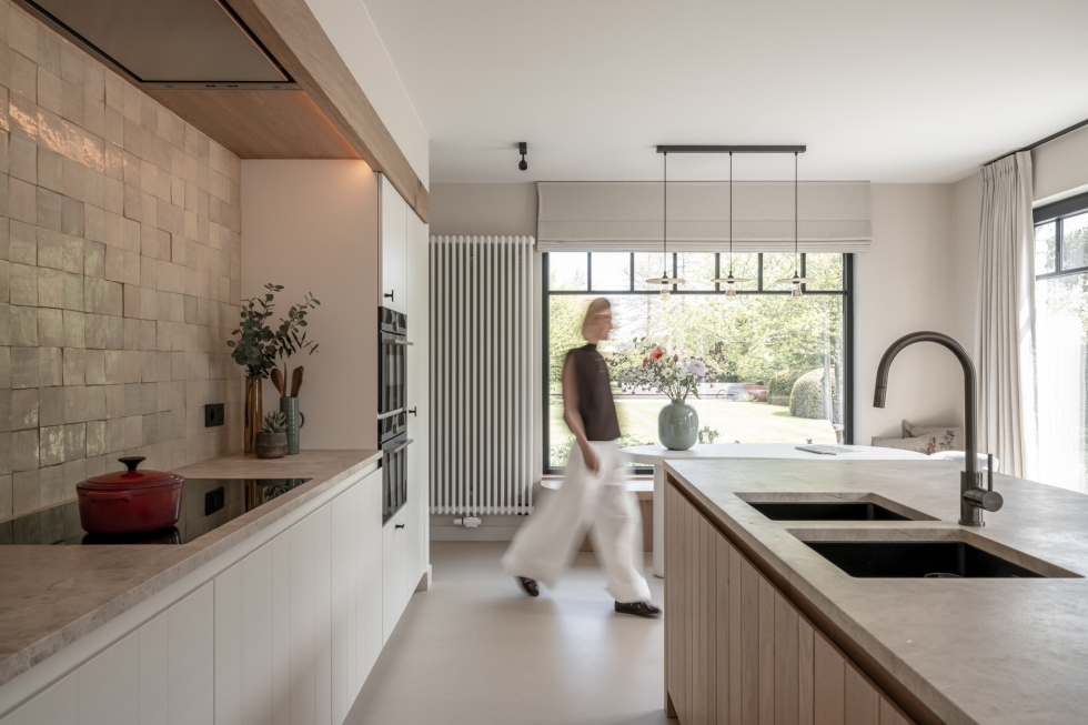 Vrouw loopt door gerenoveerde keuken
